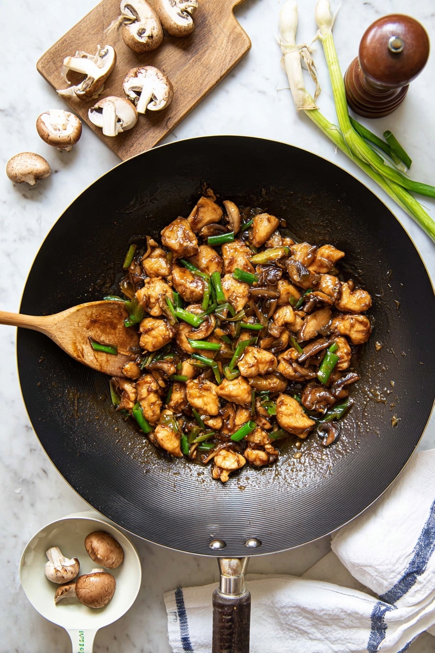 Black Pepper Mushroom Chicken Stir Fry, easy mushroom chicken stir fry, quick weeknight chicken stir fry, flavorful mushroom chicken dish, Asian-style chicken mushroom stir fry - A large black wok filled with several small pieces of golden-brown cooked chicken mixed with sliced brown mushrooms and bright green chopped spring onions, all coated in a glossy brown sauce. A wooden spoon stirs the mixture from the left side of the wok. Around the wok, there are whole and sliced mushrooms, a wooden pepper grinder, fresh green spring onions on a small wooden board, and a white measuring cup holding two mushrooms. The entire scene is set on a white marbled surface with a white cloth towel showing blue stripes placed under the wok’s handle. photo taken with an iphone --ar 2:3 --v 7