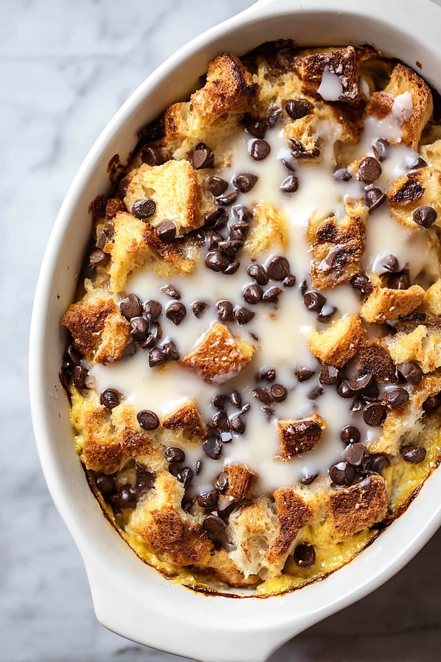 Tres Leches Bread Pudding with Chocolate Chips, Tres Leches Bread Pudding, Bread Pudding with Chocolate Chips, Easy Tres Leches Dessert, Moist Brioche Bread Pudding - A white oval dish filled with a baked dessert featuring a rough top layer of golden brown bread chunks mixed with melted dark chocolate chips scattered evenly. Below this, a creamy, slightly crispy, yellow layer is visible, soaked with a white glaze drizzled across the top, adding a shiny texture. The edges of the dish show browned and slightly caramelized spots, giving a crunchy look to the dessert. The dish rests on a white marbled surface. photo taken with an iphone --ar 2:3 --v 7