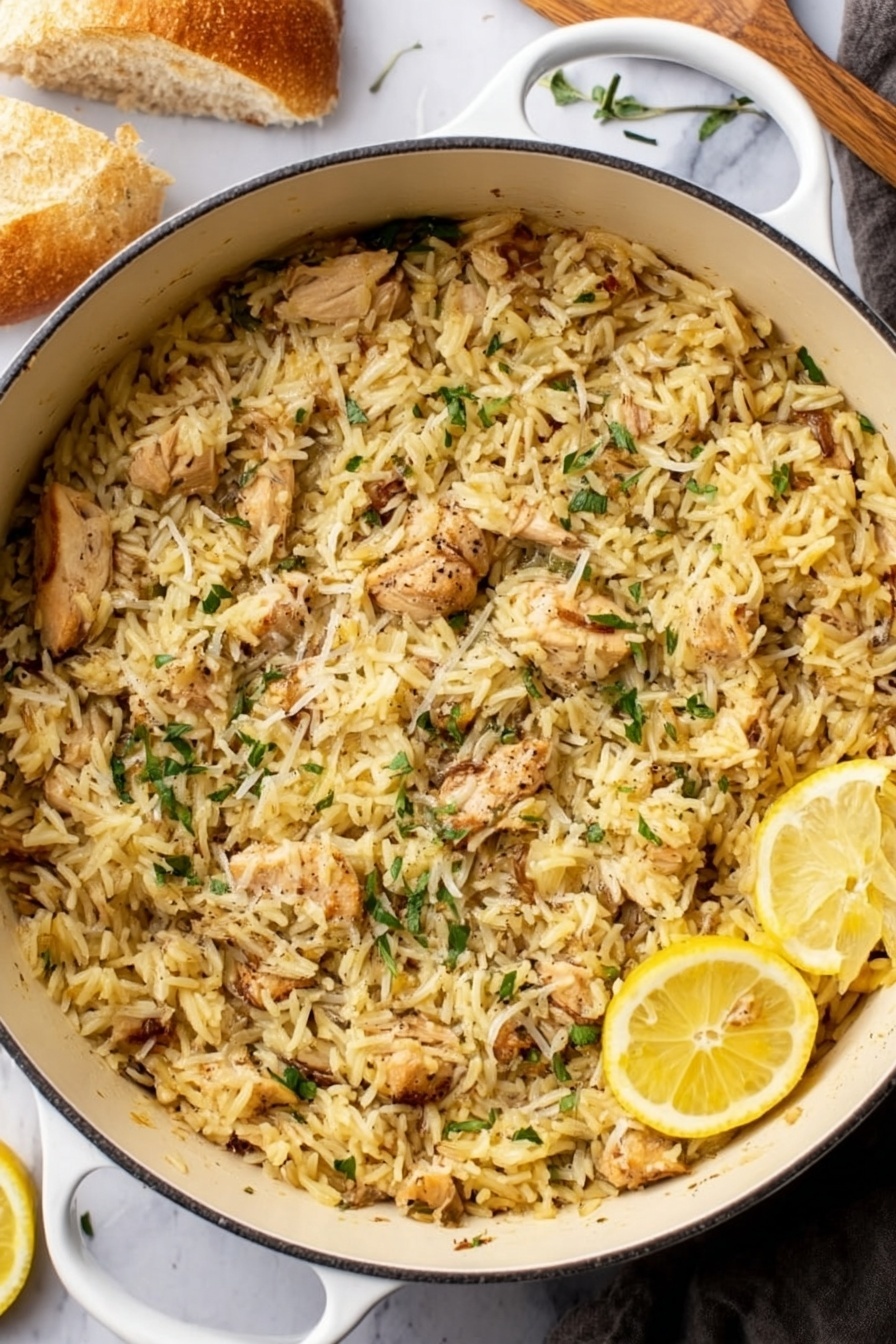 Lemon Chicken and Orzo, Lemon Chicken and Orzo dinner, easy lemon chicken pasta, one-pan lemon chicken, quick lemon chicken recipes - A white pot filled to the top with cooked yellowish rice mixed with small pieces of light-brown cooked chicken, scattered with thin green herb leaves and a sprinkle of grated cheese or seasoning on top, with two thin lemon slices resting near the edge of the pot. The pot is placed on a white marbled surface with a piece of bread in the top left corner and a woman's hand in the lower left corner holding a utensil. photo taken with an iphone --ar 2:3 --v 7
