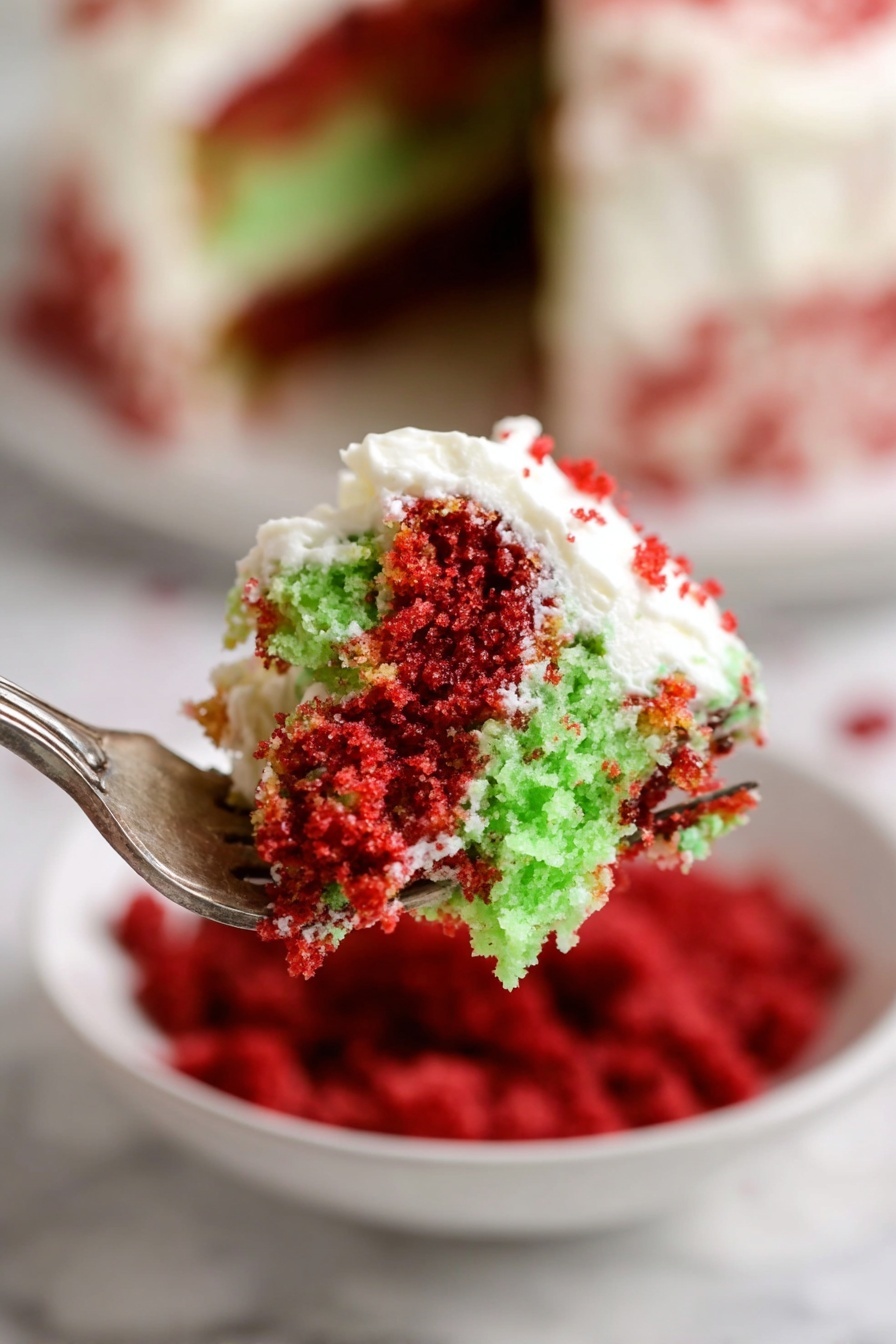 Christmas Red Velvet Trifle, festive Christmas dessert, holiday layered trifle, easy Christmas dessert, red velvet cake trifle - A close-up view of a fork holding a bite of two-layer cake with bright red and light green crumb layers, topped with white creamy frosting that is slightly spread over both layers, showing a mix of crumb textures and smooth frosting. In the background, a white bowl filled with red crumbs and a white marbled surface are slightly blurred, enhancing focus on the cake piece. The layering and vivid colors make the dessert look inviting and fresh. photo taken with an iphone --ar 2:3 --v 7