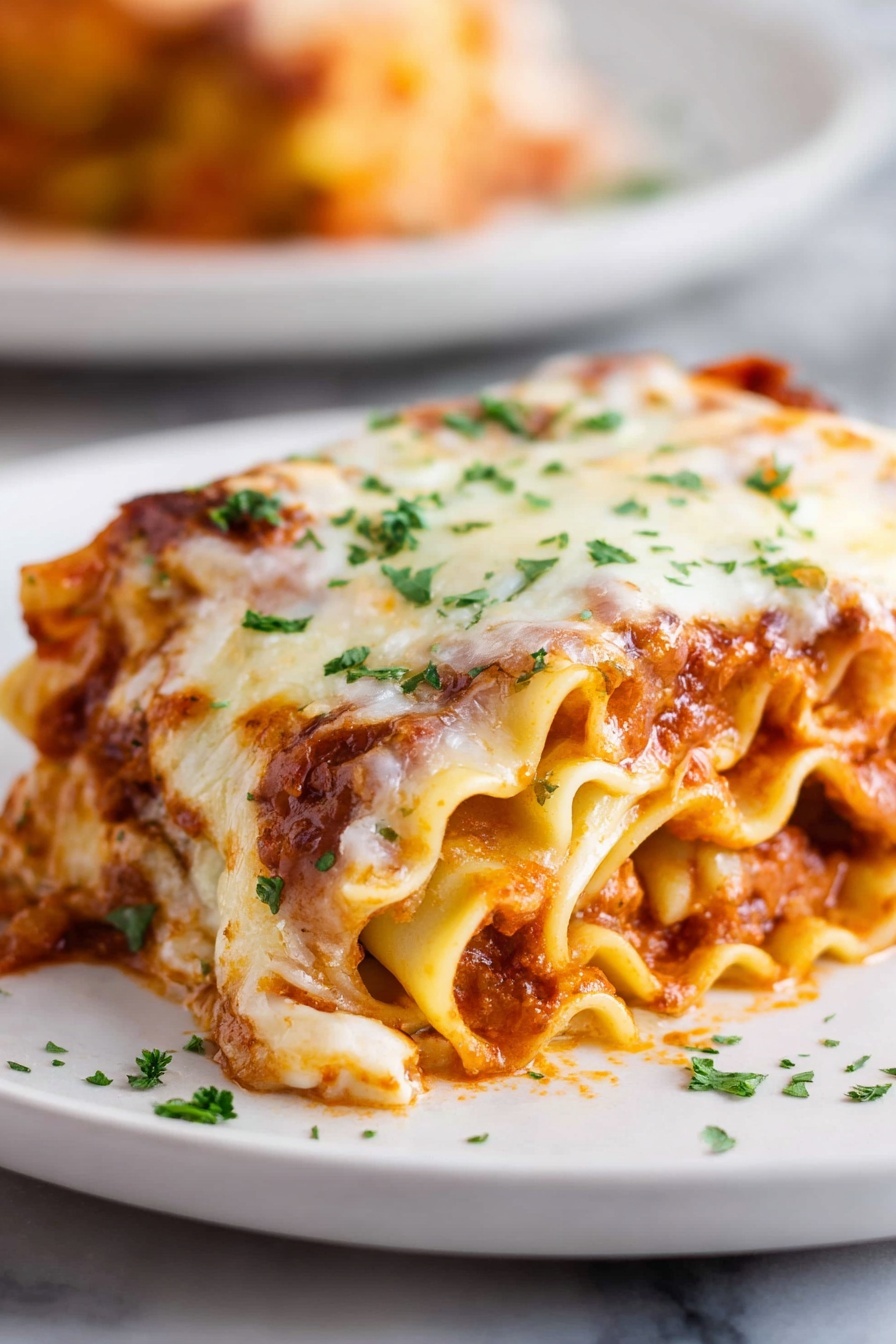Cheesy Beef Lasagna Roll-Ups, easy lasagna roll-ups, beef and cheese roll-ups, weeknight dinner ideas, portable lasagna dishes - A rolled lasagna piece sits on a white plate with soft, wavy pasta layers visible on the sides. The lasagna has three layers inside, filled with a mix of rich red tomato sauce and light orange cheese sauce. The top is covered with a thick layer of melted white cheese that has some golden brown spots, sprinkled with small green parsley leaves. The plate is placed on a white marbled surface, and there is a blurred second plate in the background. Photo taken with an iphone --ar 2:3 --v 7