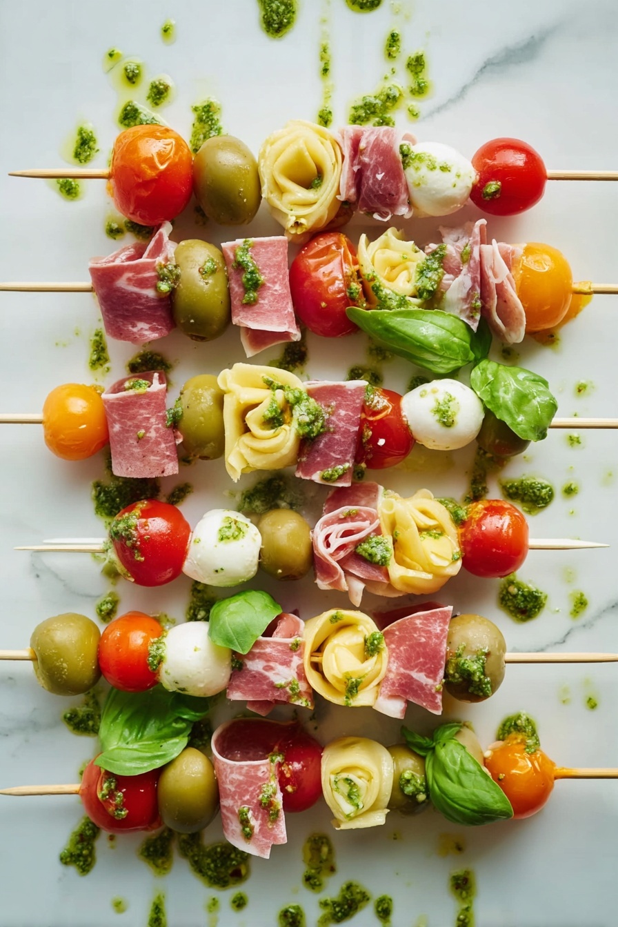 Antipasto Skewers with Tortellini and Cheese, antipasto skewers, easy appetizer ideas, summer party appetizers, no-cook snack recipes - The image shows several skewers with five to seven layers each, arranged side by side on a white marbled surface. Each skewer has colorful ingredients stacked in this order from top to bottom: red cherry tomatoes or orange cherry tomatoes, green basil leaves or whole green olives, light yellow tortellini pasta, thin swirled slices of pink cured meat, and white cheese cubes or white mozzarella balls. Some layers also have small pieces of bright red roasted pepper. Green pesto sauce is drizzled over the skewers and on the surface around them, adding an extra texture and shine to the image. The overall look is fresh, vibrant, and neatly arranged. photo taken with an iphone --ar 2:3 --v 7
