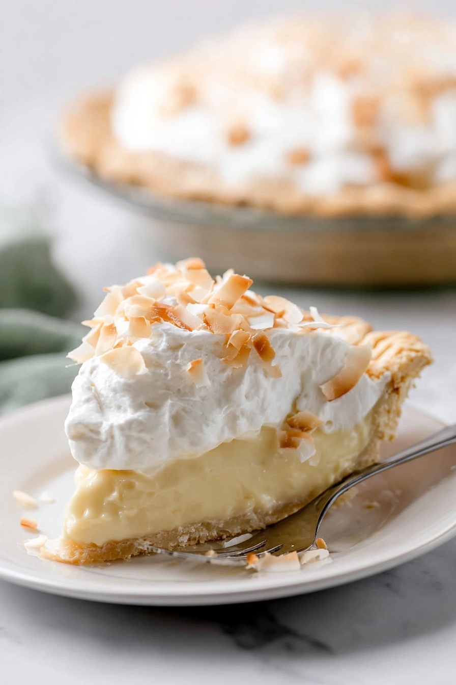 Homemade Coconut Cream Pie, coconut cream pie, tropical dessert, coconut pie recipe, easy coconut pie - A slice of pie is shown on a white plate, with three clear layers. The bottom layer is a light golden crust with a slightly crumbly texture. The middle layer is thick and creamy, pale yellow in color, smooth and soft looking. The top layer is white whipped cream, fluffy, covered with toasted coconut flakes that are light brown and white, scattered unevenly. The pie is on a white marbled surface, and in the background, the rest of the pie is visible in a clear pie dish. A silver fork with text is placed beside the slice on the plate. photo taken with an iphone --ar 2:3 --v 7
