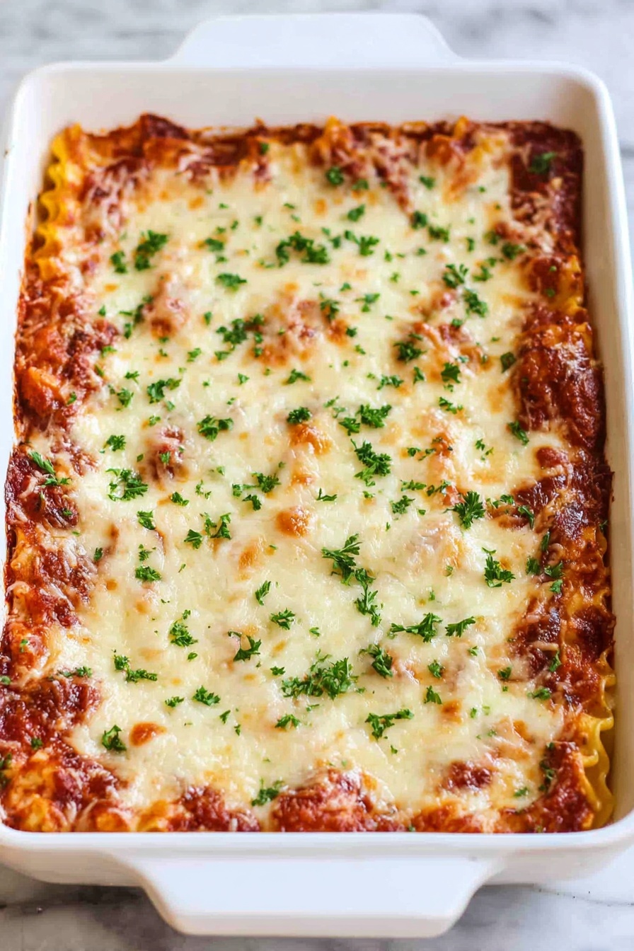 Cheesy Beef Lasagna Roll-Ups, easy lasagna roll-ups, beef and cheese roll-ups, weeknight dinner ideas, portable lasagna dishes - A white rectangular baking dish filled with a layered lasagna. The top layer is melted cheese with golden brown spots and sprinkled with small green parsley pieces. The layer underneath shows hints of a rich red tomato sauce and pasta edges peeking through. The dish is placed on a white marbled surface. photo taken with an iphone --ar 2:3 --v 7