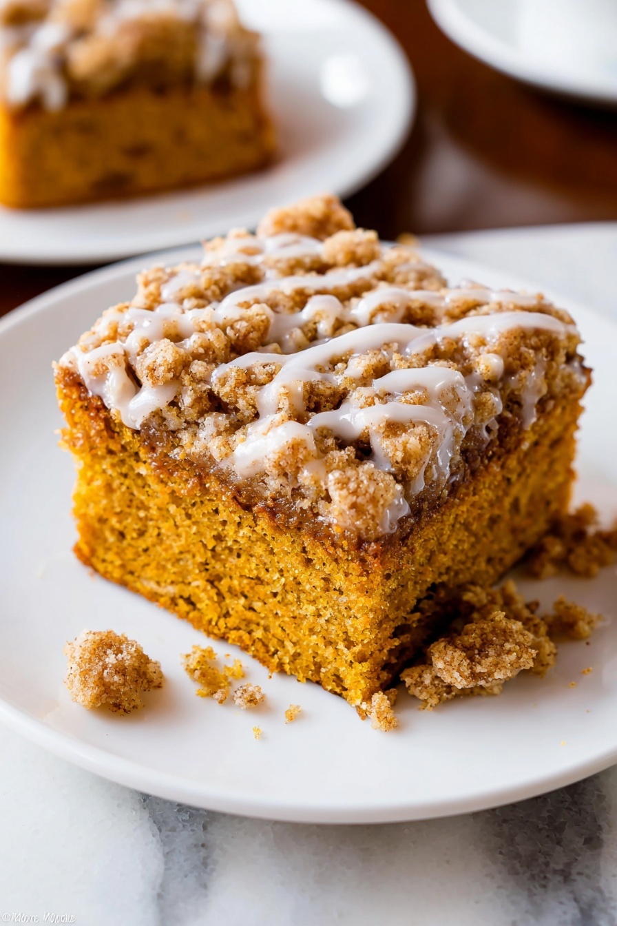 Pumpkin Crumb Coffee Cake, pumpkin coffee cake with crumb topping, fall pumpkin breakfast cake, moist pumpkin coffee cake recipe, easy pumpkin coffee cake - A close-up of a baked dessert square with two layers on a white plate with a raised dotted edge. The bottom layer is soft and moist, golden brown with a crumbly texture. The top layer is a thicker, crumbly streusel with a light brown color and a drizzle of white icing. A piece has been taken out with a silver fork resting on the plate holding some crumbs and icing. The plate sits on a white marbled surface. Photo taken with an iphone --ar 2:3 --v 7