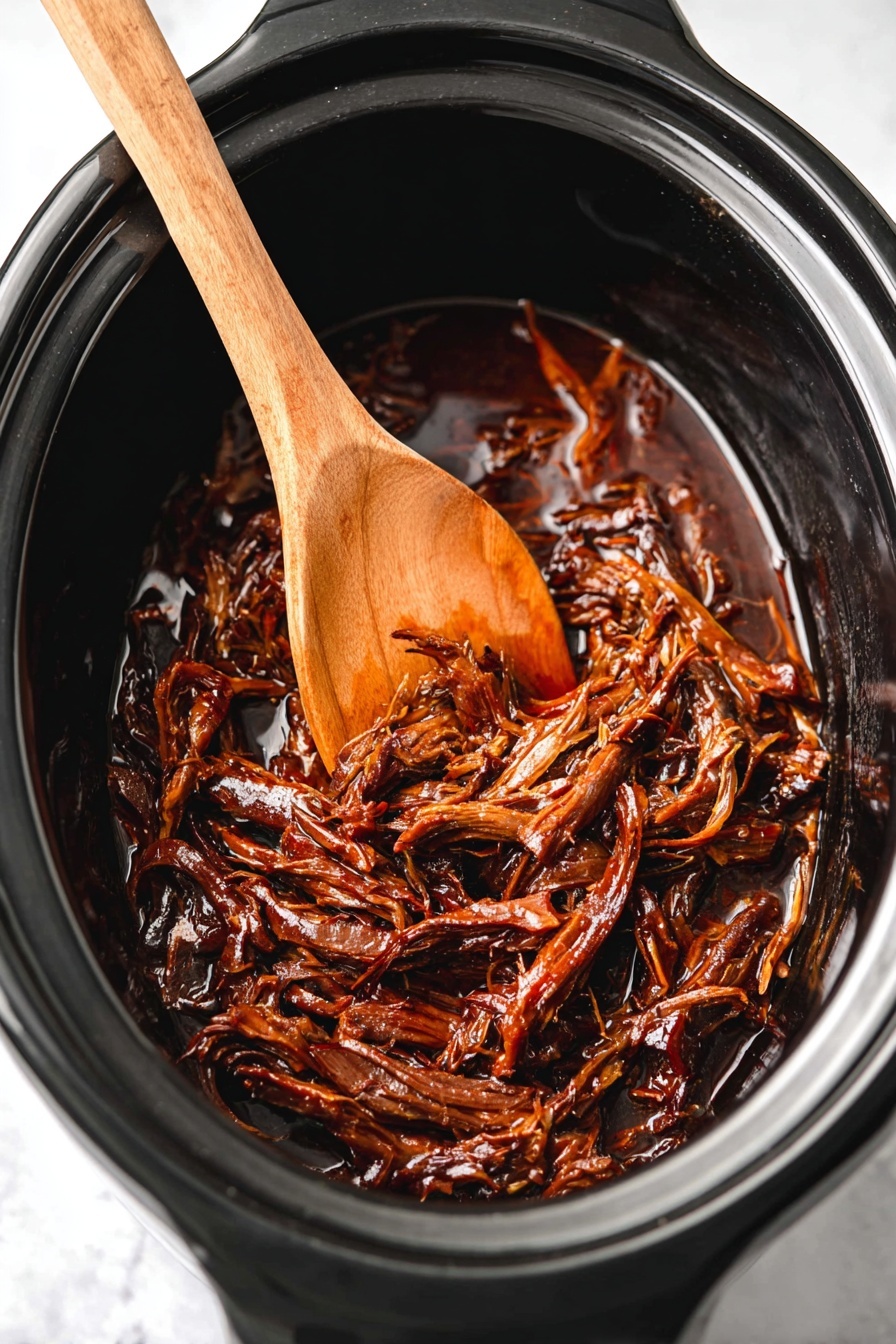 Slow Cooker Honey BBQ Beef Brisket, BBQ brisket recipe, easy slow cooker beef, tender beef brisket, flavorful beef dishes - Inside a black slow cooker, there is a single layer of dark brown shredded meat with a shiny, sticky sauce coating it. Resting partially on top of the meat is a wooden spoon with a smooth brown texture. The slow cooker sits on a white marbled surface. photo taken with an iphone --ar 2:3 --v 7