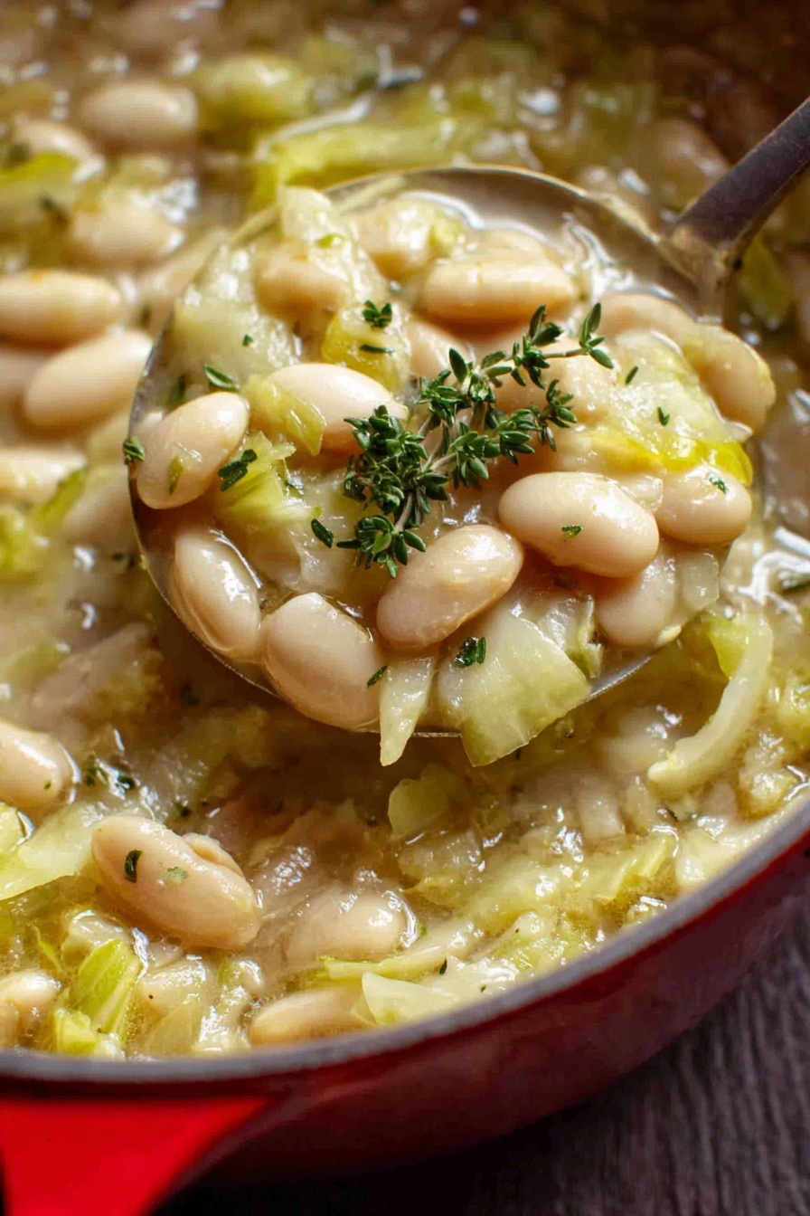 Creamy Butter Beans with Leeks, butter beans with leeks, savory leek and bean dish, comforting vegetarian main, easy creamy bean recipe - The image shows a close-up view of a red pot filled with a warm soup made of white beans and chopped green cabbage pieces in a light broth. The beans are smooth and oval-shaped, scattered evenly throughout the soup, while the cabbage is soft and lightly translucent with a pale green color. Small specks of black pepper and fresh thyme sprigs are sprinkled on top for garnish. The pot has a shiny red exterior with a white interior and two handles on the sides. The pot is sitting on a white marbled surface. Photo taken with an iphone --ar 2:3 --v 7