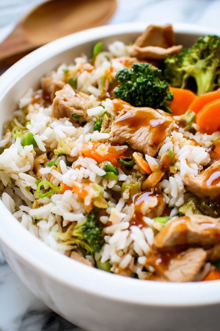 Teriyaki Chicken Casserole, easy chicken casserole recipes, weeknight dinner ideas, homemade teriyaki sauce, delicious chicken bake - The image shows a white bowl filled with a colorful stir-fry dish on a white marbled surface. The dish has three main layers: at the bottom, there is a layer of cooked rice with a light brown color and fluffy texture. The middle layer contains a mix of bright orange baby carrots, green snap peas, and small broccoli florets, giving the dish a fresh and vibrant look. The top layer is a light drizzle of dark brown sauce covering parts of the rice and vegetables, adding a shiny finish. The overall look is warm and inviting, with a mix of soft and crisp textures visible. Photo taken with an iphone --ar 2:3 --v 7