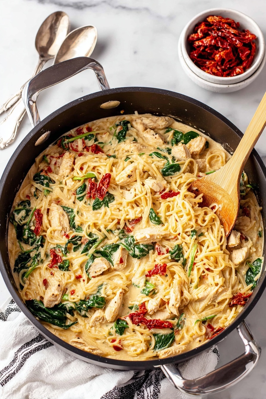 Tuscan Chicken with Spaghetti Squash, healthy chicken and spaghetti squash dish, low-carb chicken recipes, easy Italian chicken dinner, flavorful spaghetti squash meals - A large black pan filled with a creamy pasta dish that has three main layers: the creamy sauce with melted cheese forms the base, mixed through with tender pieces of seasoned light brown chicken, bright green spinach leaves, and small chunks of red sun-dried tomatoes scattered evenly throughout. A light wooden spoon is stirring the mixture from the right side of the pan. Near the pan, on a white marbled surface, sits a small white bowl filled with more red sun-dried tomatoes and a silver spoon nearby. A white cloth with black stripes is placed casually under the pan handle. Photo taken with an iphone --ar 2:3 --v 7