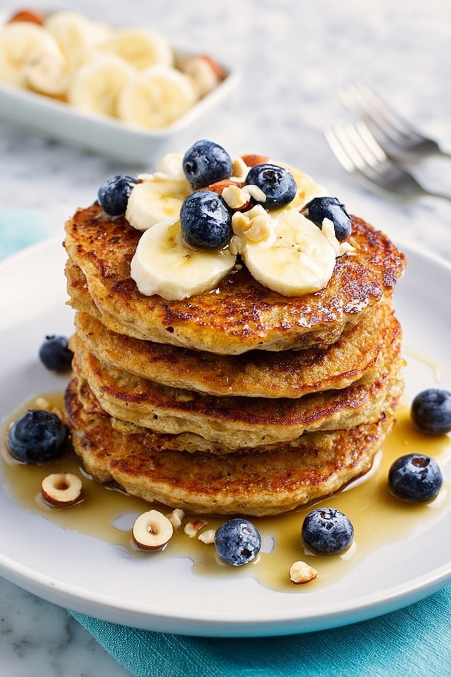 Healthy Banana Oatmeal Pancakes, healthy pancake recipes, nutritious breakfast ideas, easy oatmeal banana pancakes, gluten-free breakfast ideas - A stack of five thick golden-brown pancakes sits in the center of a white plate on a white marbled surface. The pancakes have a slightly crispy edge and a soft texture visible on the sides. On top, there is a layer of banana slices that are creamy yellow, mixed with small deep blue blueberries and a few light-colored hazelnuts. Honey or syrup drizzles over the top and pools around the base, giving a shiny, sticky finish. More blueberries and hazelnuts are scattered around the plate. In the background, a white dish with banana slices and a fork rest on the white marbled surface. photo taken with an iphone --ar 2:3 --v 7