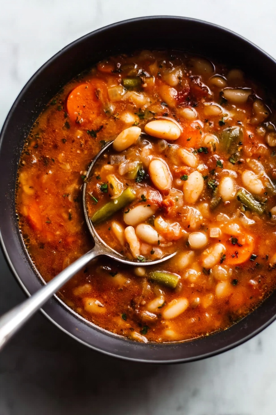 Easy Vegetarian Minestrone Soup, vegetarian minestrone soup, healthy minestrone recipe, hearty vegetable soup, quick vegetarian soup - A close-up view of a dark bowl filled with a thick soup that has many white beans, slices of orange carrots, and small pieces of green beans mixed in a rich, reddish-brown broth. The soup looks chunky with visible bits of vegetables and herbs throughout, giving it a hearty and comforting appearance. A shiny silver ladle with a long handle rests inside the bowl, partially submerged in the soup, with the handle leaning on the edge of the bowl. The bowl sits on a white marbled surface. Photo taken with an iphone --ar 2:3 --v 7