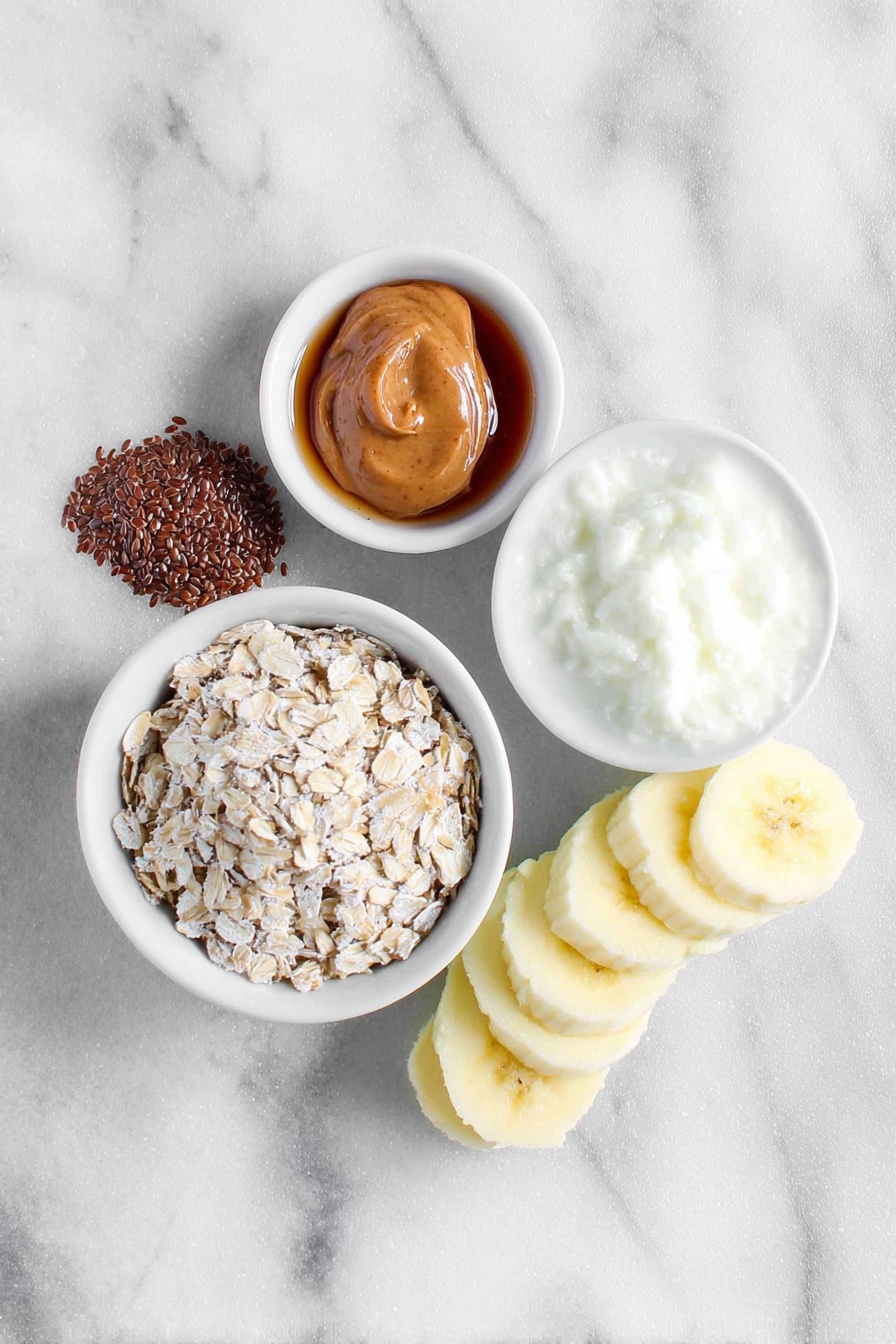 Peanut Butter Banana Overnight Oats, healthy overnight oats, easy breakfast ideas, make-ahead breakfast recipes, nutritious breakfast oats - Flat lay of a small mound of rolled oats, a teaspoon of whole flax seeds, a light dusting of ground cinnamon beside a small white ceramic bowl of milk, a small white ceramic bowl filled with amber maple syrup, a dollop of creamy peanut butter on the side, and a perfectly ripe half banana sliced into neat pieces arranged next to the ingredients, all placed on a clean white marble surface, soft natural light, photo taken with an iPhone, professional food photography style, fresh ingredients, white ceramic bowls, no bottles, no duplicates, no utensils, no packaging --ar 2:3 --v 7 --p m7354615311229779997